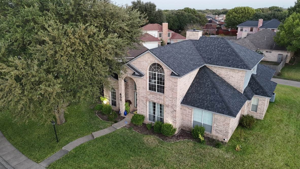 Two-story brick home with a new roof, seen from above