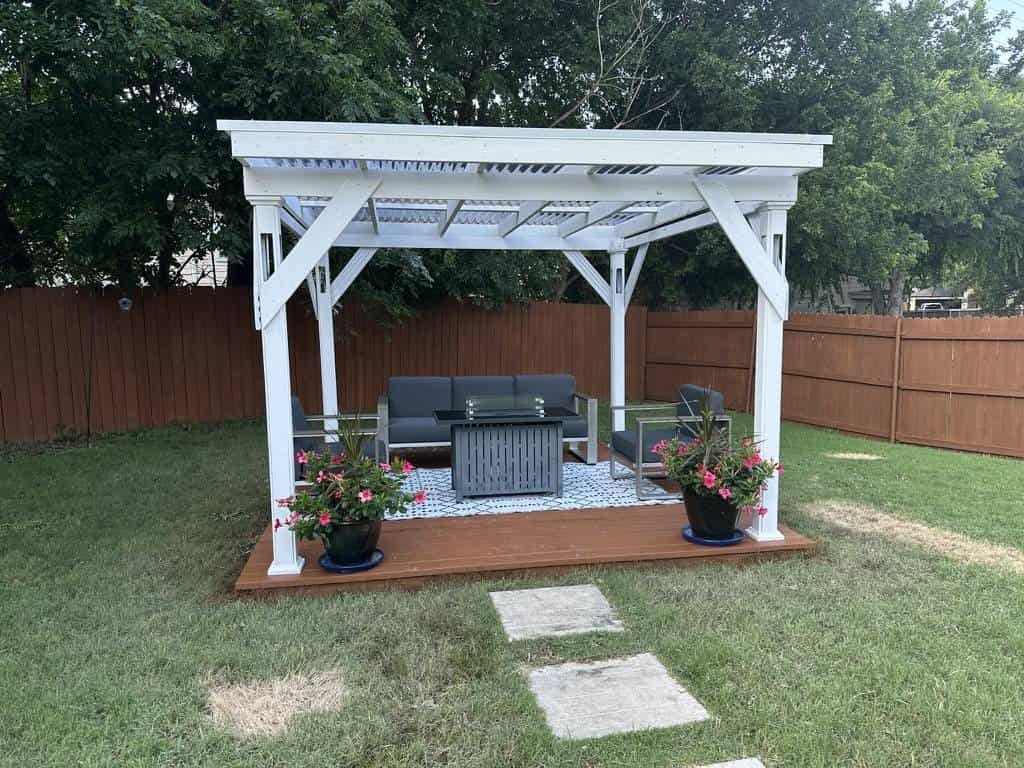 Backyard pergola and patio beside a wood privacy fence