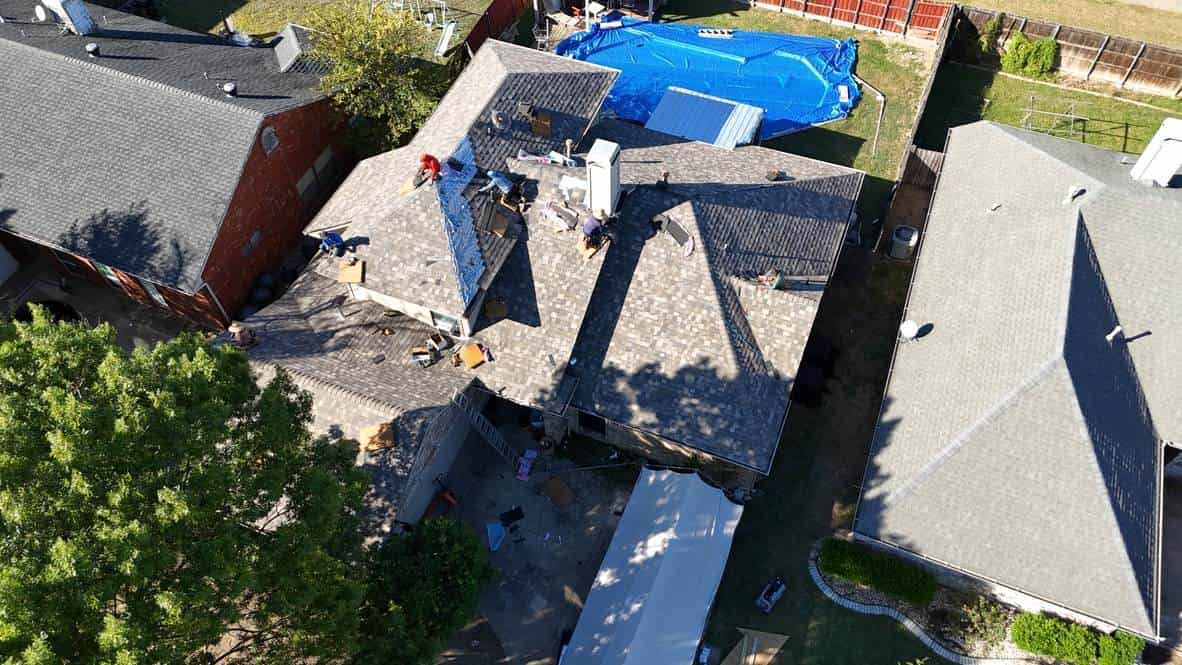 Roof replacement in progress, with tarps protecting the property
